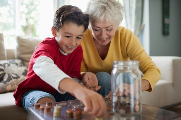 A grandparent counting coins with their grandchild.